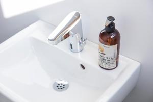 una bottiglia di alcol seduta su un lavandino del bagno di Norrland YMCA Hostel Umeå a Umeå