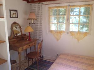 Schlafzimmer mit einem Schreibtisch, einem Bett und einem Fenster in der Unterkunft la maison bleue in Carros