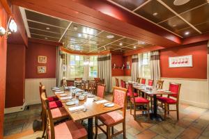 a restaurant with wooden tables and red walls at Best Western Station Hotel in Dumfries