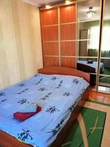 a bed with a blue comforter on top of it at Apartments on Dontsya, 12 in Kyiv