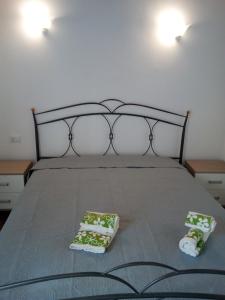 una camera con un letto con due cuscini sopra di Miniappartamento' Mare e sole Lascari Cefalù a Lascari