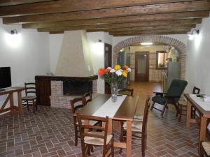sala de estar con mesa y chimenea en Agriturismo Battaglia, en Villamassargia