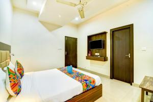 a bedroom with a bed and a flat screen tv at FabHotel Solitaire Inn in Kānpur