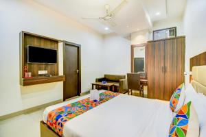 a hotel room with a bed and a television at FabHotel Solitaire Inn in Kānpur