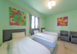 una habitación de hospital con 2 camas y una silla en Kinmen Line In Bed and Breakfast, en Jinhu