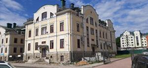 a large white building on the side of a street at Academy of Hostel in Kostroma