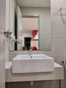 W łazience znajduje się biała umywalka i lustro. w obiekcie Strait Garden Suites X Ace Pro @ George Town w mieście Jelutong