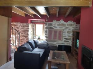 een woonkamer met een bank en een tafel bij Casita Morada in Navalespino