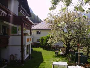 um quintal de uma casa com uma mesa e uma árvore em Haus Marion em Jerzens
