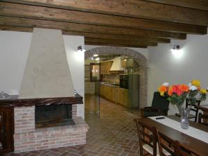 Agriturismo Battaglia في Villamassargia: مطبخ وغرفة معيشة مع موقد من الطوب