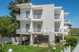 a white building with a sign in front of it at Georgalas Rest Apartments in Nea Kalikratia