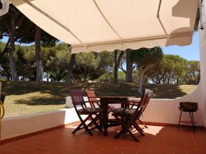 a table and chairs under an umbrella on a patio at Apartamento Passarinhos in Albufeira