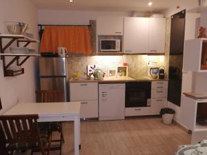 a small kitchen with white cabinets and a table at Apartamento Passarinhos in Albufeira