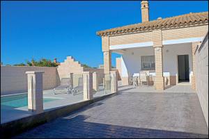una casa con patio e piscina di Chalet Peñuelas con piscina a Conil de la Frontera