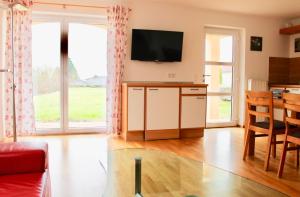 a living room with a flat screen tv on the wall at Villa Donautal in Inzigkofen