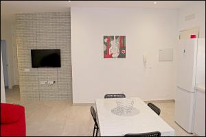 un tavolo bianco con sedie in una camera con TV di Chalet Peñuelas con piscina a Conil de la Frontera Altre 22 foto