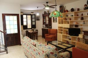 a living room with a couch and a chair and a television at Casa Nieves in Ronda