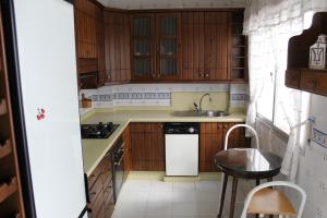 a kitchen with wooden cabinets and a sink and a dishwasher at Casa Nieves in Ronda