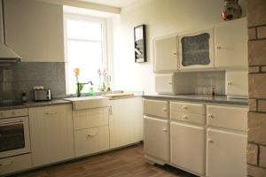 a kitchen with white cabinets and a sink and a window at Bauernhof Gerth in Göllnitz