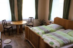 1 Schlafzimmer mit 2 Betten, einem Tisch und Fenstern in der Unterkunft Bauernhof Gerth in Göllnitz