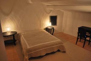 a bedroom with a bed and two tables and a piano at Mas 20 personnes en Drôme provençale, région de Nyons in Chaudebonne