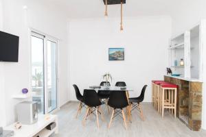 une salle à manger avec une table et des chaises noires dans l'établissement Iliana Sea Side House, à Elounda