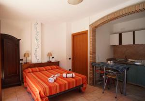 a bedroom with a bed and a table and a kitchen at Residenza Su Prelau in Gonnesa