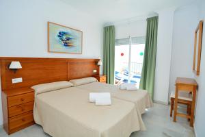 Cama ou camas em um quarto em Apartamentos HC Burriana Playa
