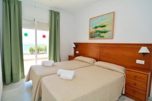 Cama ou camas em um quarto em Apartamentos HC Burriana Playa