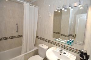 a bathroom with a white toilet and a sink at Apartamentos HC Burriana Playa in Nerja