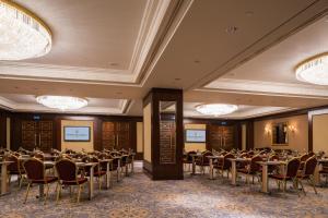a conference room with tables and chairs and chandeliers at InterContinental - Kyiv by IHG in Kyiv +155 photos