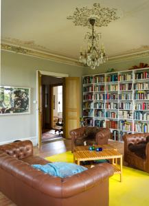 a living room with leather furniture and bookshelves at Liebacksgården in Skegrie