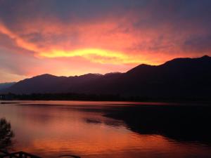 un tramonto su un lago con montagne sullo sfondo di Blue Lake a Lovere