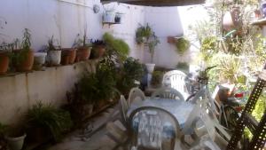 a patio with a table and a bunch of plants at Stelios Rooms to Rent in Chania