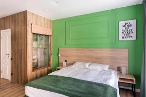 Dormitorio verde con cama y pared verde en Hotel Demut, en San Petersburgo