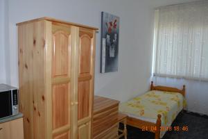 1 dormitorio con armario de madera y cama en Guest House Orbita, en Tyulenovo
