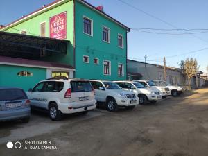 una fila de autos estacionados frente a un edificio en BESQALA, en Nukus