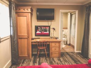 Zimmer mit einem Schreibtisch und einem TV an der Wand in der Unterkunft Biggy Best Boutique Hotel & Self Catering Cottages in Howick