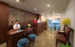 tres personas de pie en un bar en el vestíbulo en Vision Premium Hotel en Hanoi