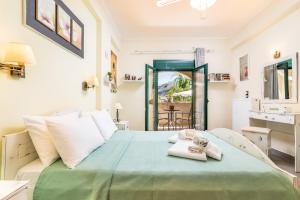 Un dormitorio con una cama verde con toallas. en Lakoudia, en Pitsidia