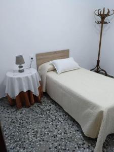 Schlafzimmer mit einem Bett und einem Beistelltisch in der Unterkunft Casa Vall de Almonacid in Vall de Almonacid