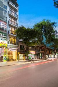 una calle de la ciudad frente a un edificio alto en Vision Premium Hotel en Hanoi