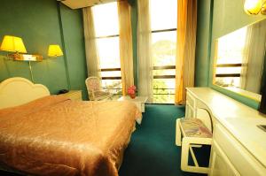 een hotelkamer met een bed en een raam bij Glorieta Hotel in Sucre