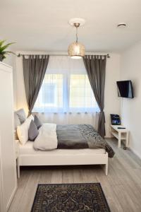ein Schlafzimmer mit einem weißen Bett und einem Fenster in der Unterkunft Im kleinen Stil ll in Linz am Rhein