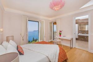 una camera da letto con un letto grande con vista sull'oceano di Villa Touran a Orasac (Valdinoce)