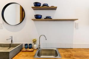 a kitchen with a sink and a mirror at Leaf Signature Hotel - Lá Group in Ho Chi Minh City +46 photos