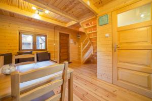 Blockhütte mit einem Bett und Holzboden in der Unterkunft Osada nad Dziwną domki nad morzem in Dziwnów + 20 Fotos