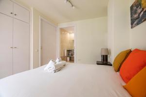 バルセロナにあるビー バルセロナ アシャンプラ ウルキナオナ IIのベッドルーム(大きな白いベッド、オレンジ色の枕付)