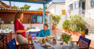 two women sitting at a table eating food at Mira Mare Hotel, Galaxidi in Galaxidi