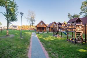 a park with wooden houses and a playground at Osada nad Dziwną domki nad morzem in Dziwnów